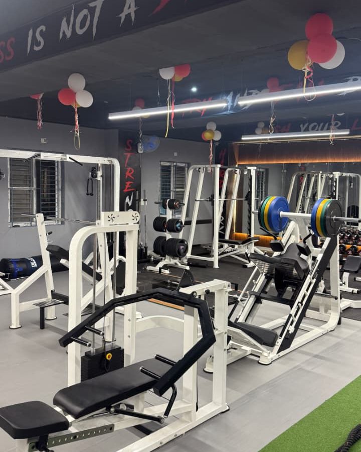 The main floor — leg press, racks and loaded barbells